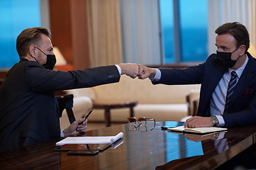 Image showing business people wearing face mask on meeting and handshake