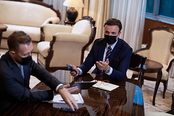 Image showing business people wearing crona virus protection face mask on meeting