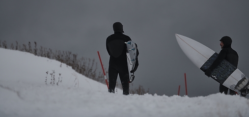 Image showing Arctic surfers running on beach after surfing