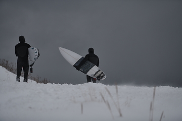 Image showing Arctic surfers running on beach after surfing