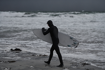 Image showing Arctic surfer going by beach after surfing