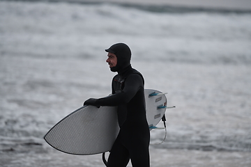 Image showing Arctic surfer going by beach after surfing