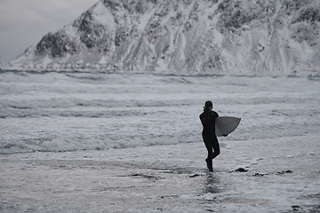 Image showing Arctic surfer going by beach after surfing