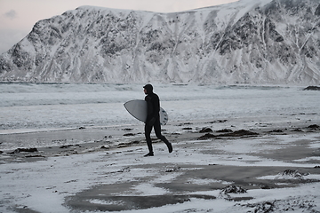 Image showing Arctic surfer going by beach after surfing