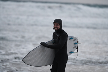 Image showing Arctic surfer going by beach after surfing