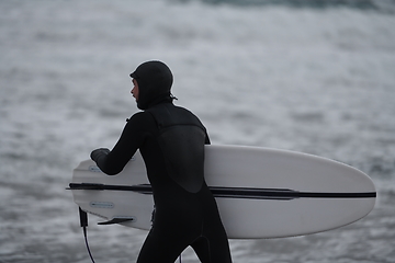 Image showing Arctic surfer going by beach after surfing