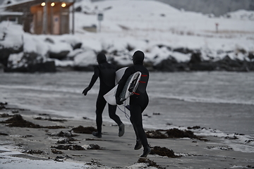 Image showing Arctic surfers running on beach after surfing