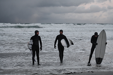 Image showing Arctic surfers going by beach after surfing