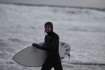 Image showing Arctic surfer going by beach after surfing