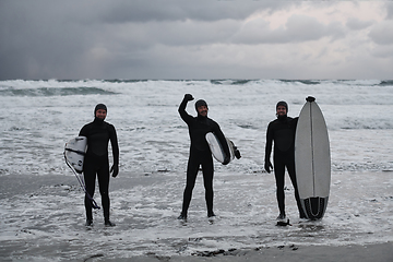 Image showing Arctic surfers going by beach after surfing