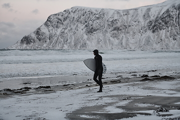 Image showing Arctic surfer going by beach after surfing