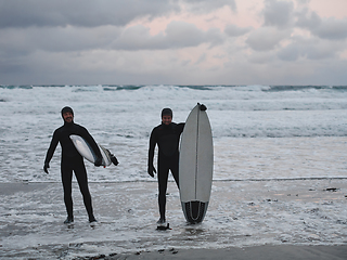 Image showing Arctic surfers going by beach after surfing