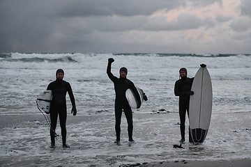 Image showing Arctic surfers going by beach after surfing