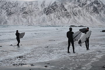 Image showing Arctic surfers going by beach after surfing