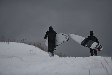 Image showing Arctic surfers running on beach after surfing