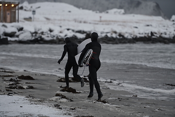 Image showing Arctic surfers running on beach after surfing