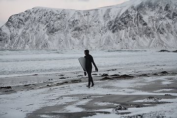 Image showing Arctic surfer going by beach after surfing