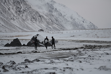 Image showing Arctic surfers going by beach after surfing