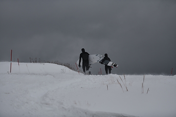 Image showing Arctic surfers running on beach after surfing