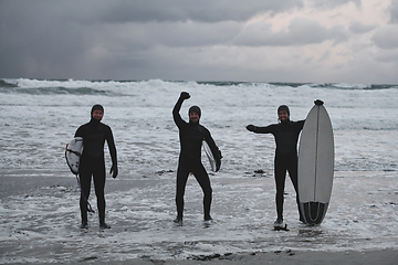 Image showing Arctic surfers going by beach after surfing