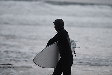 Image showing Arctic surfer going by beach after surfing