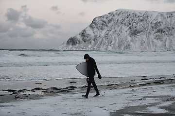 Image showing Arctic surfer going by beach after surfing