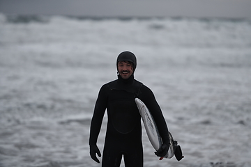 Image showing Arctic surfer going by beach after surfing