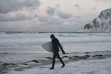 Image showing Arctic surfer going by beach after surfing