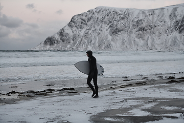 Image showing Arctic surfer going by beach after surfing