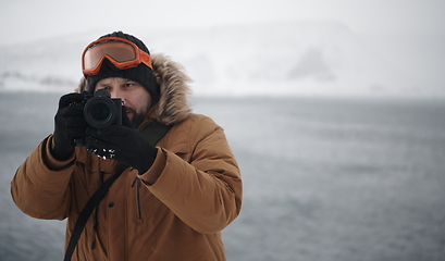 Image showing photographer at winter in stormy weather wearing warm fur jacket