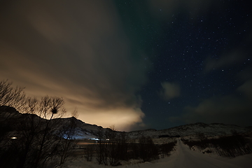 Image showing Aurora borealis Green northern lights above mountains