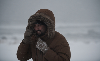 Image showing man at winter in stormy weather wearing warm fur jacket