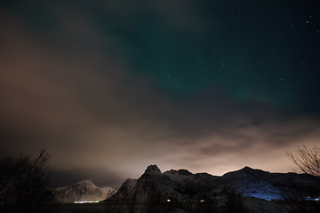 Image showing Aurora borealis Green northern lights above mountains