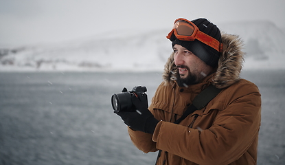 Image showing photographer at winter in stormy weather wearing warm fur jacket