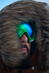 Image showing man at winter in stormy weather wearing warm fur jacket