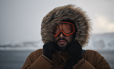 Image showing man at winter in stormy weather wearing warm fur jacket