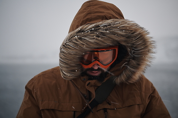 Image showing man at winter in stormy weather wearing warm fur jacket