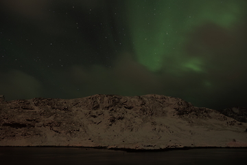 Image showing Aurora borealis Green northern lights above mountains