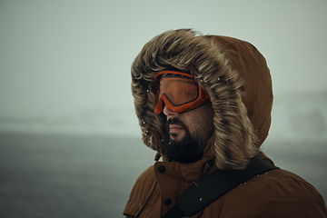 Image showing man at winter in stormy weather wearing warm fur jacket