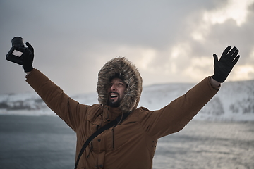 Image showing photographer at winter in stormy weather wearing warm fur jacket