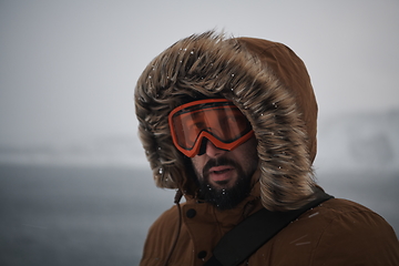 Image showing man at winter in stormy weather wearing warm fur jacket