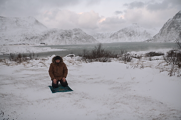 Image showing Muslim traveler praying in cold snowy winter day