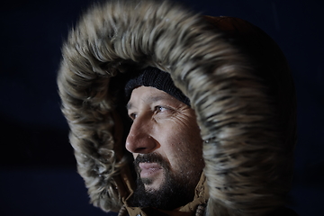 Image showing man at winter in stormy weather night wearing warm fur jacket