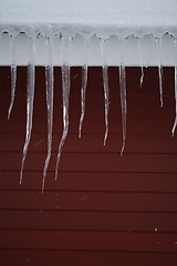 Image showing icicles on the roof of a red house in Norway