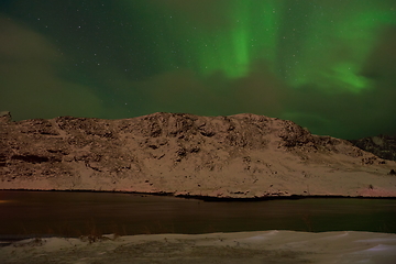 Image showing Aurora borealis Green northern lights above mountains