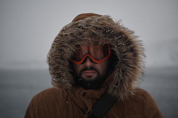 Image showing man at winter in stormy weather wearing warm fur jacket