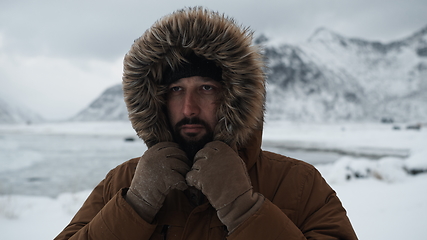 Image showing man at winter in stormy weather wearing warm fur jacket