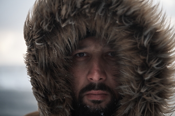 Image showing man at winter in stormy weather wearing warm fur jacket