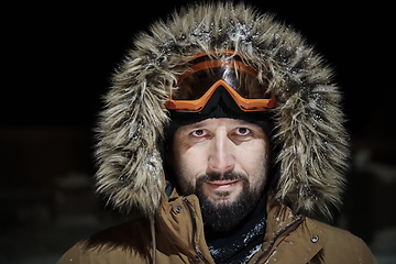 Image showing man at winter in stormy weather night wearing warm fur jacket