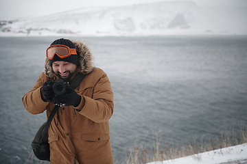 Image showing photographer at winter in stormy weather wearing warm fur jacket